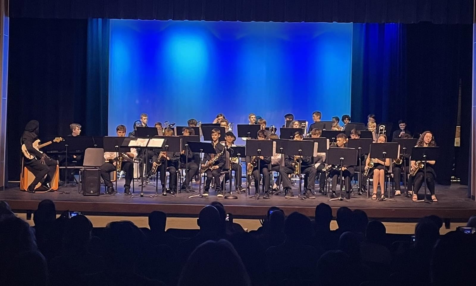 Middle school band students perform onstage